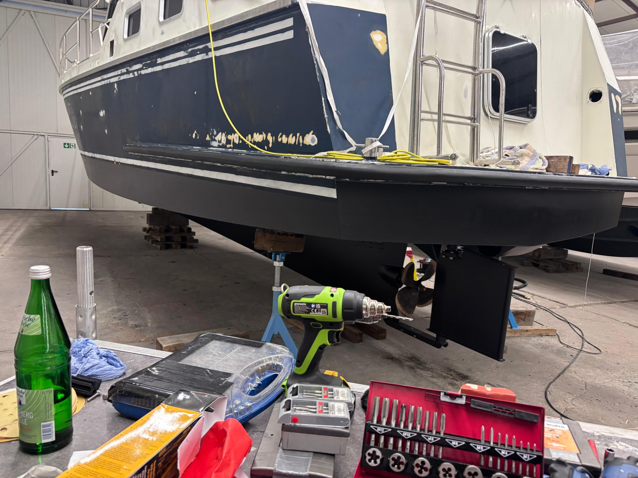 Boot in der Werft mit Werkzeugen und Ausrüstung, bereit für Wartung an der Marina.
