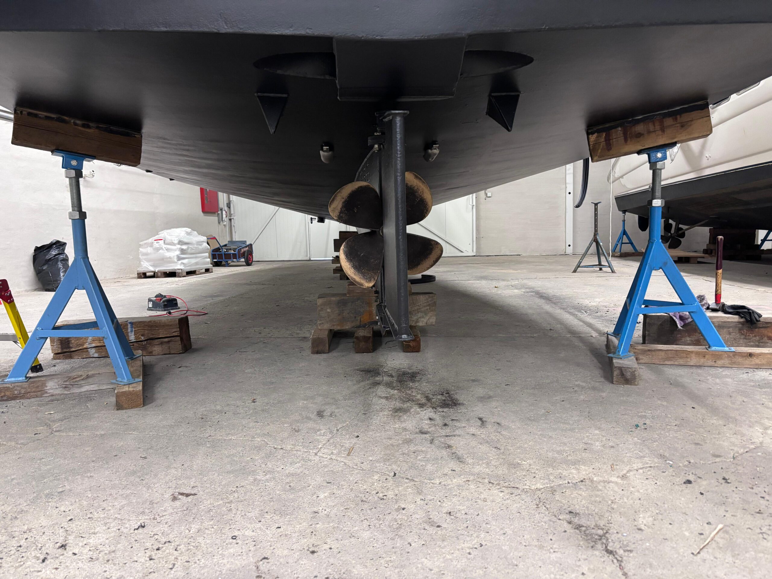 Boot im Hafen auf Bootssteg, Blick auf Propeller und Rumpf.
